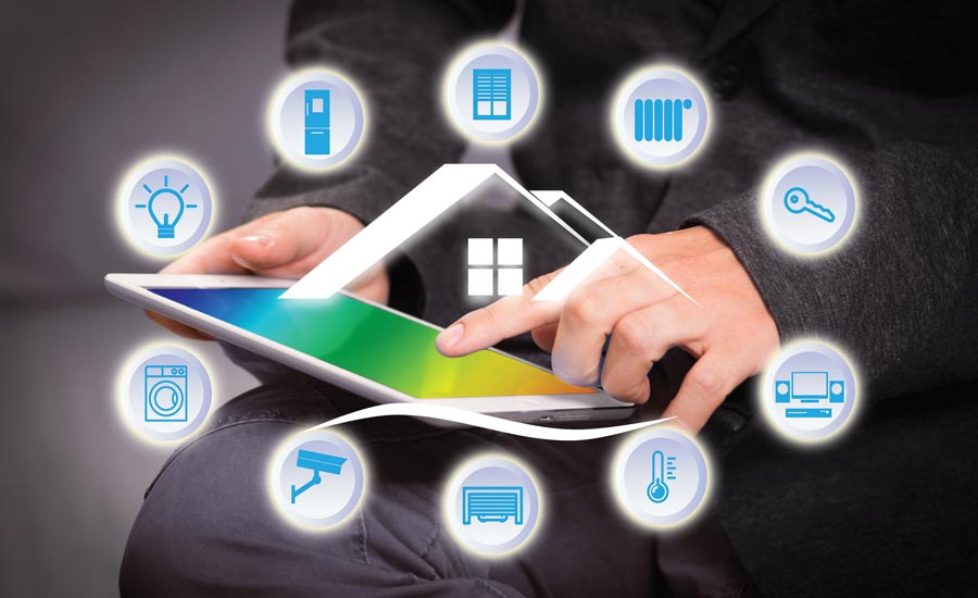 A hand using a tablet, ringed by glowing icons for lighting, heating, a security camera, a washing machine, a garage door and a thermostat around the outline of a house
