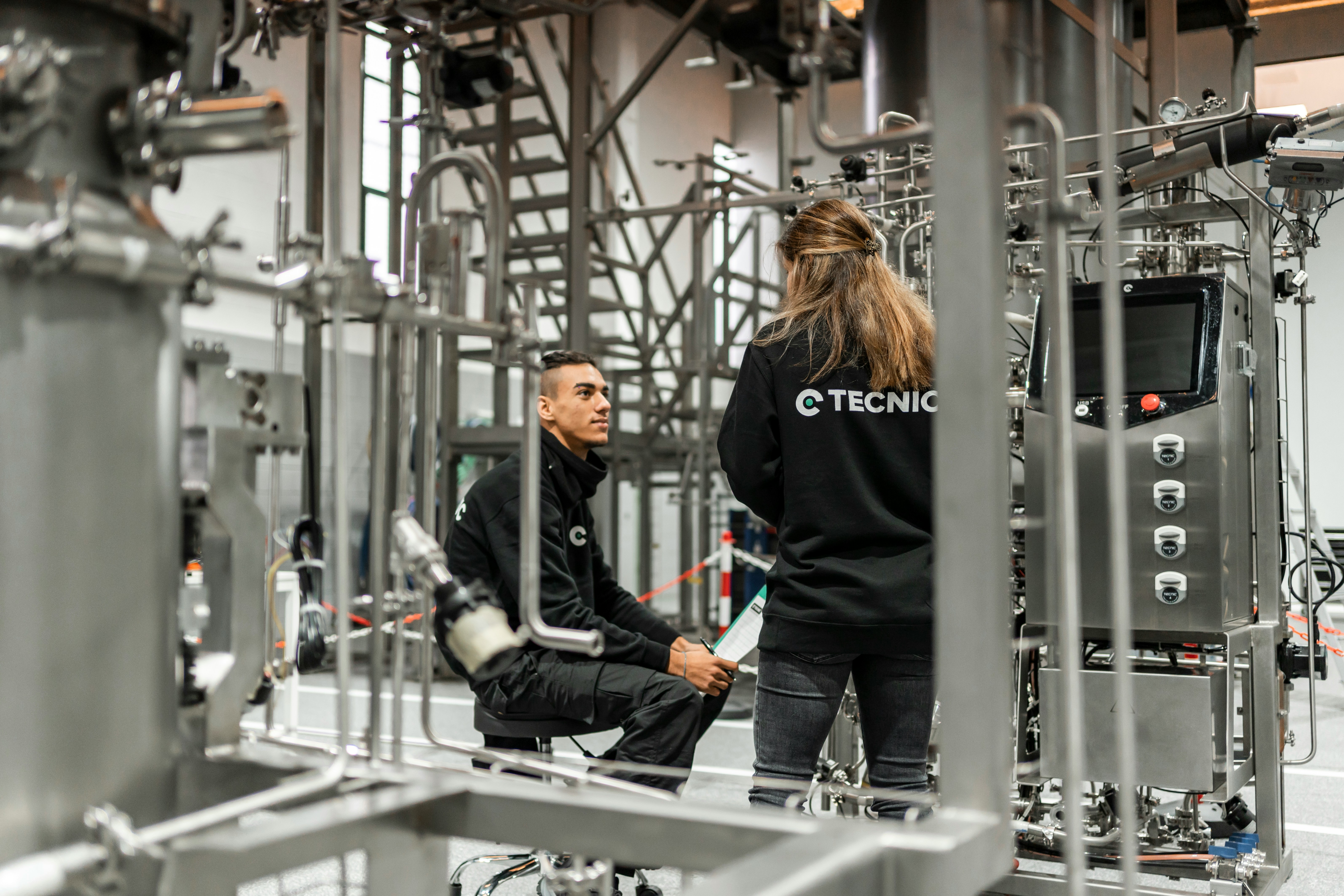 two technicians discuss factory equipment
